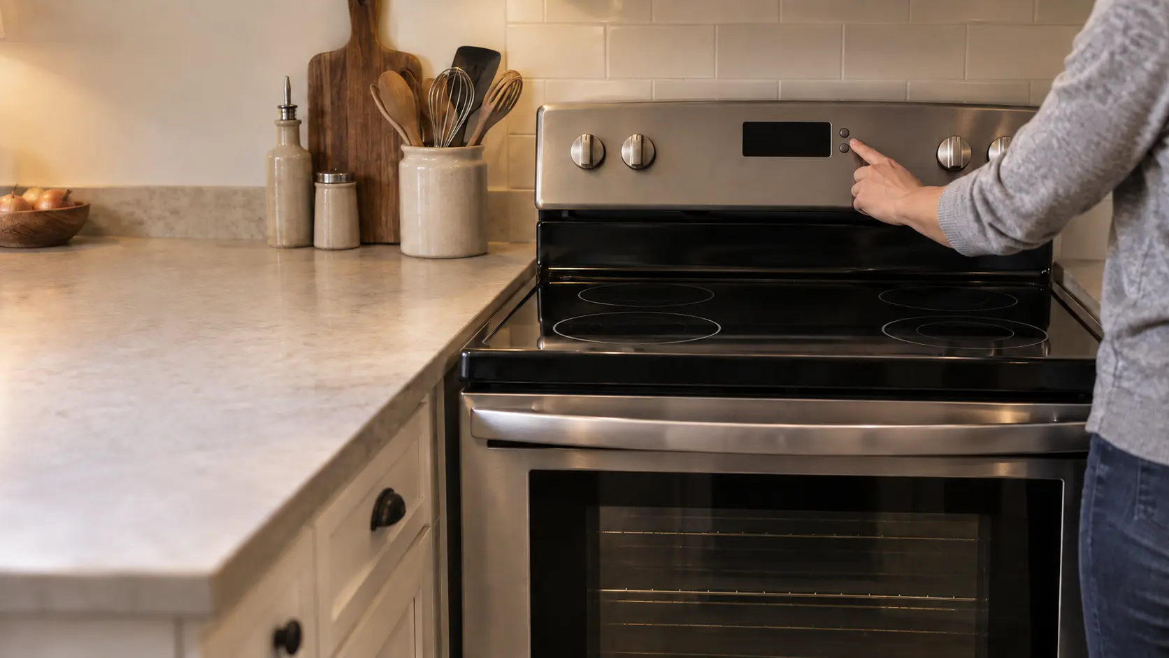 A hand resetting the clock on the back guard of a stove after a power cut, the display blank.